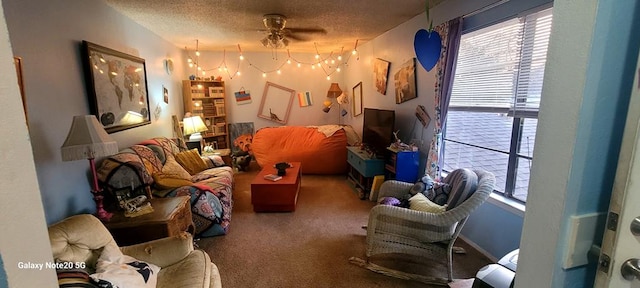 carpeted living room featuring ceiling fan and a textured ceiling