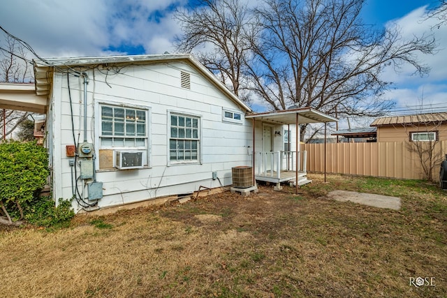 back of house with cooling unit and a yard