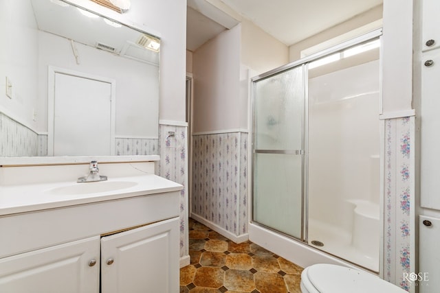 bathroom featuring walk in shower, vanity, and toilet