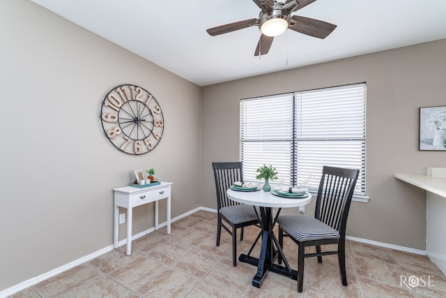 dining room featuring light tile patterned flooring, a ceiling fan, and baseboards