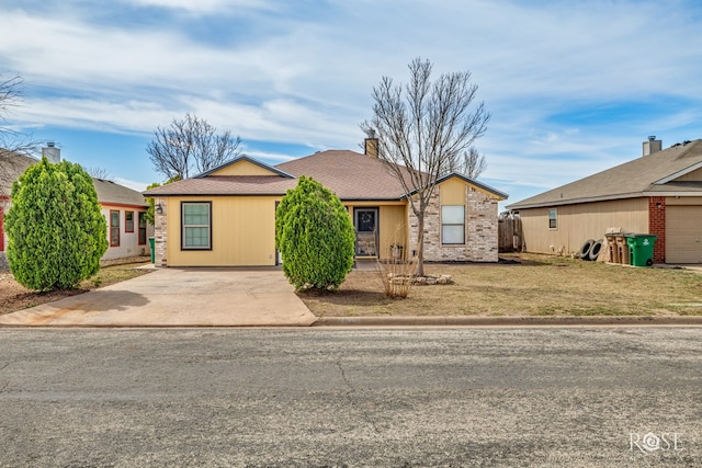 view of front of property with a front lawn, a chimney, and driveway