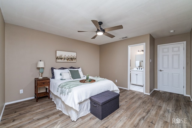 bedroom featuring a sink, visible vents, baseboards, and light wood-style flooring