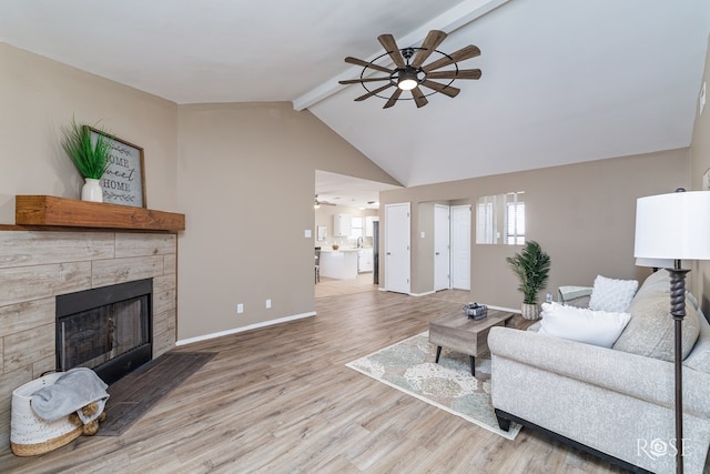 living area featuring wood finished floors, a ceiling fan, baseboards, vaulted ceiling with beams, and a fireplace with flush hearth