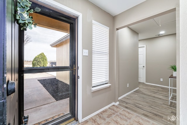 foyer entrance with visible vents and baseboards