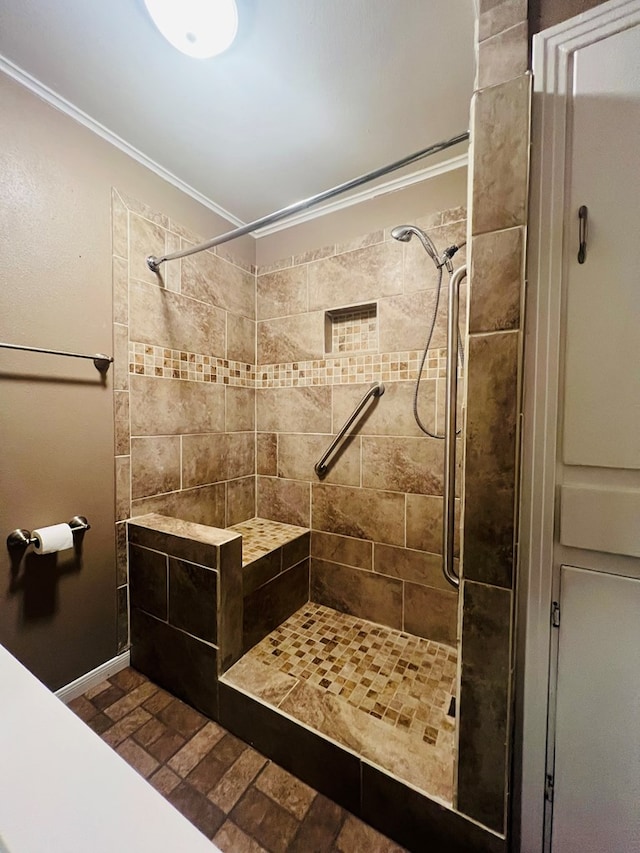 bathroom featuring a stall shower, crown molding, and baseboards