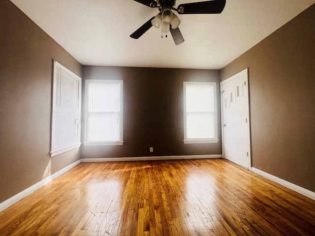 empty room featuring baseboards, ceiling fan, and light wood finished floors