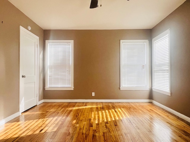 unfurnished room with ceiling fan, wood-type flooring, and baseboards