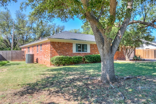 view of side of home featuring central AC unit and a lawn