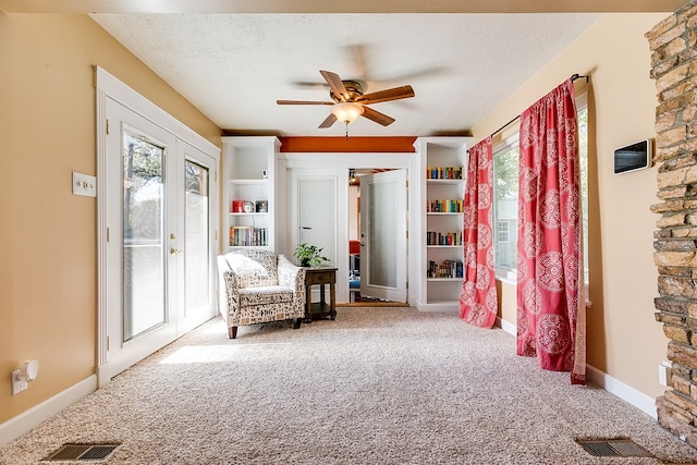 sitting room with french doors, a healthy amount of sunlight, carpet flooring, and a textured ceiling