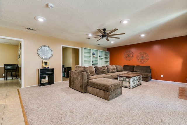 living room featuring ceiling fan, tile patterned flooring, and a textured ceiling