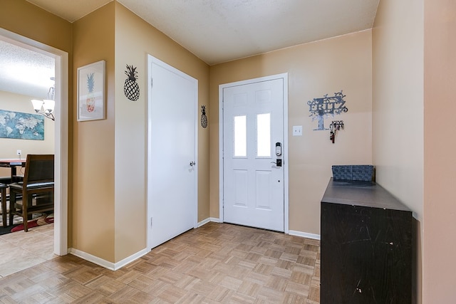 entryway featuring light parquet flooring and an inviting chandelier