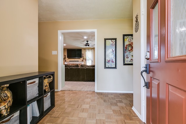 foyer entrance featuring light parquet flooring, ceiling fan, and a textured ceiling