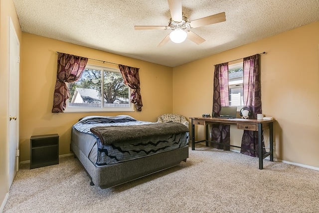 carpeted bedroom with ceiling fan and a textured ceiling