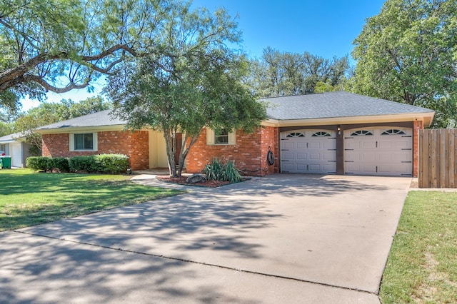 ranch-style home featuring a garage and a front lawn