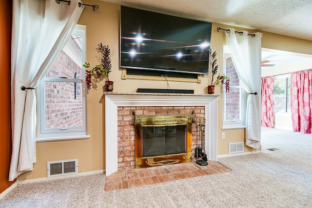 unfurnished living room featuring carpet flooring, a textured ceiling, and a fireplace