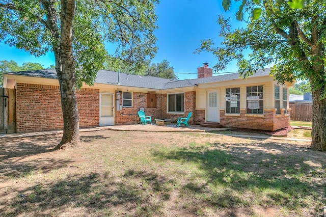 rear view of property with a yard and a patio area