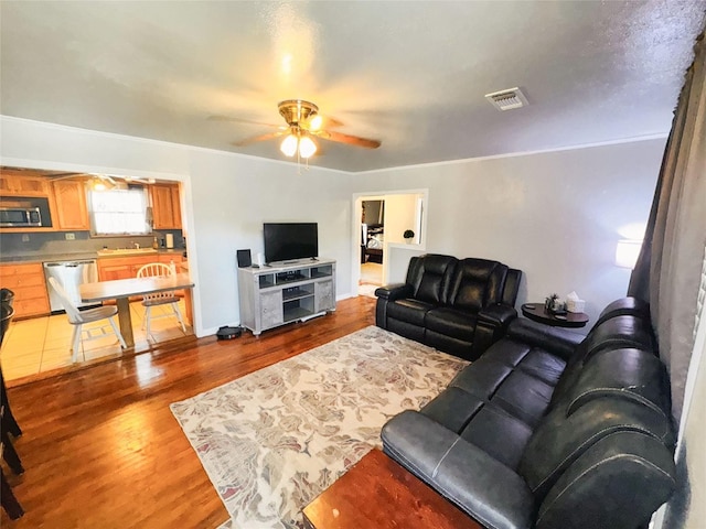 507 Hamilton Ave, Ballinger, TX 76821 - living area featuring ceiling fan, wood finished floors, and crown molding