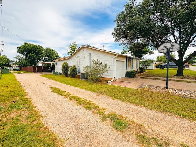 507 Hamilton Ave, Ballinger, TX 76821 - view of side of property with driveway, central air condition unit, and a yard