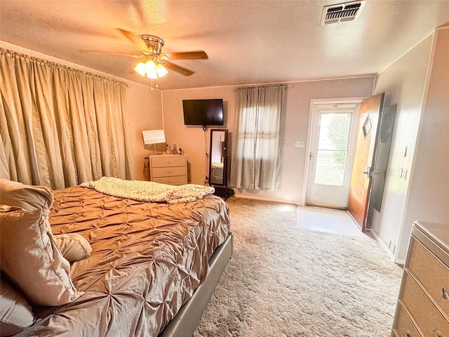 507 Hamilton Ave, Ballinger, TX 76821 - bedroom with access to exterior, carpet flooring, a textured ceiling, baseboards, and ceiling fan