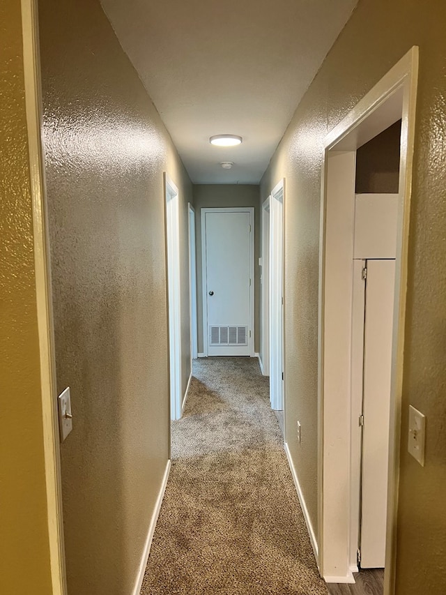 hallway featuring light colored carpet