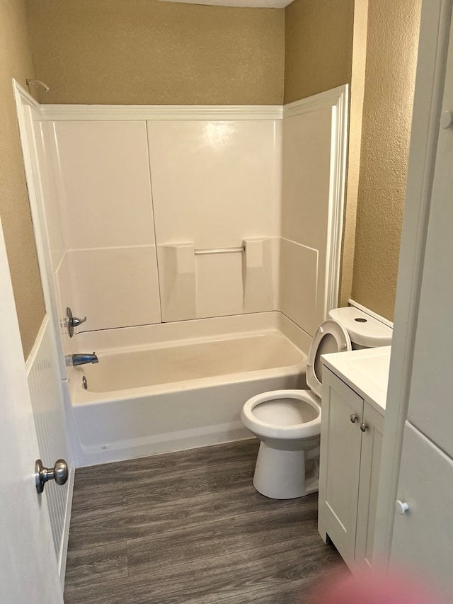 full bathroom featuring wood-type flooring, tub / shower combination, vanity, and toilet