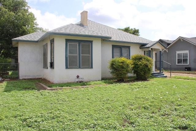 1002 Broadway St, Ballinger, TX 76821 - view of side of home featuring a shingled roof, stucco siding, and a chimney