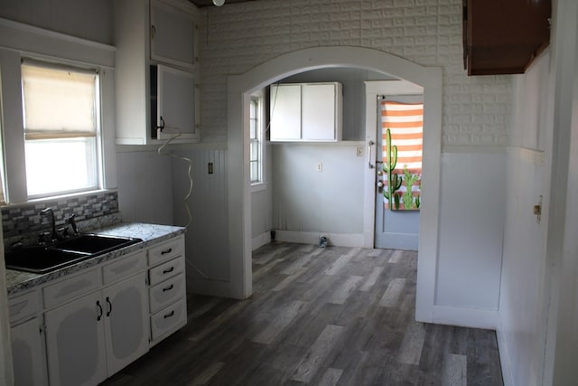 1002 Broadway St, Ballinger, TX 76821 - kitchen with white cabinets, plenty of natural light, wood finished floors, and arched walkways