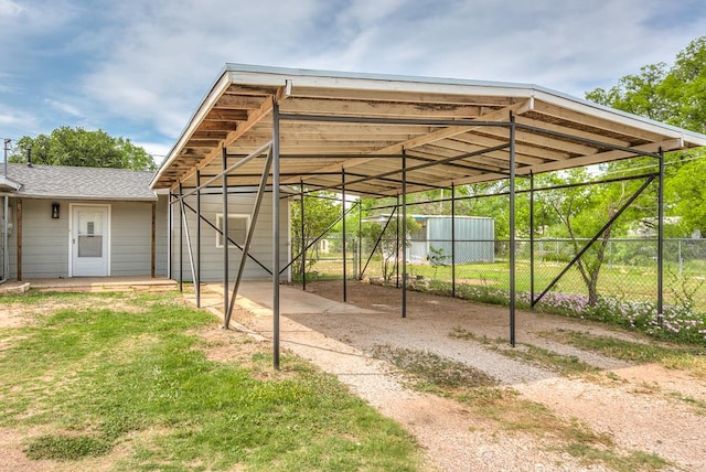 view of car parking with fence and a detached carport