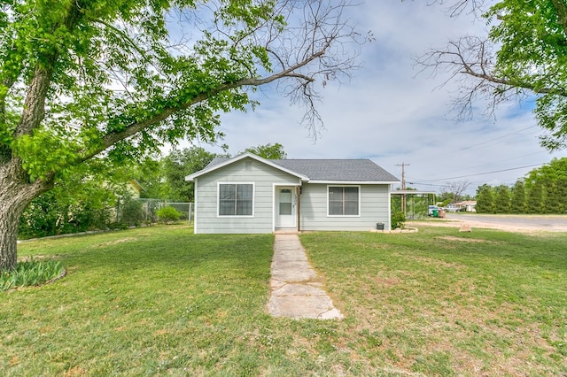 bungalow-style home featuring fence and a front lawn