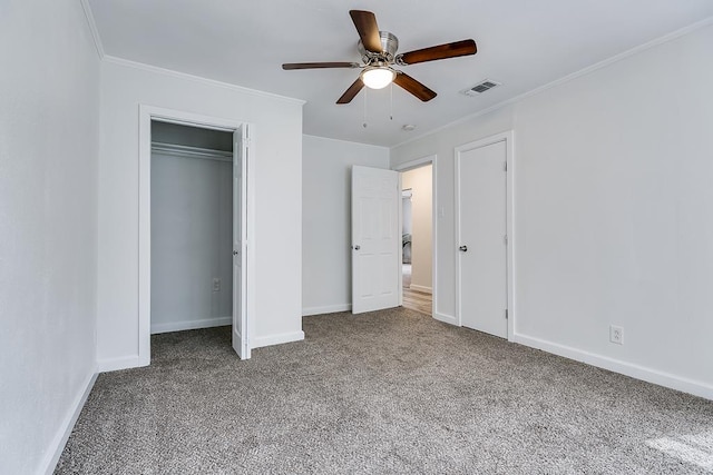 unfurnished bedroom featuring carpet floors, ornamental molding, visible vents, baseboards, and a ceiling fan