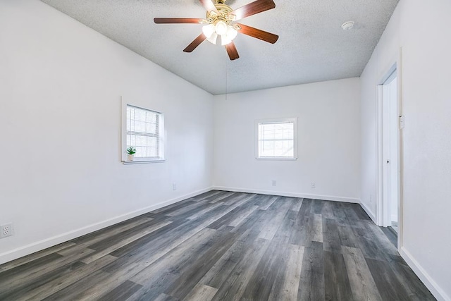 unfurnished room with baseboards, a ceiling fan, dark wood finished floors, and a textured ceiling
