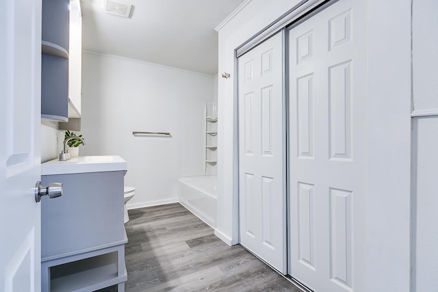 full bath with visible vents, crown molding, wood finished floors, vanity, and toilet