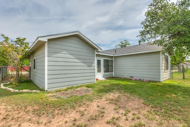 rear view of house featuring fence and a yard