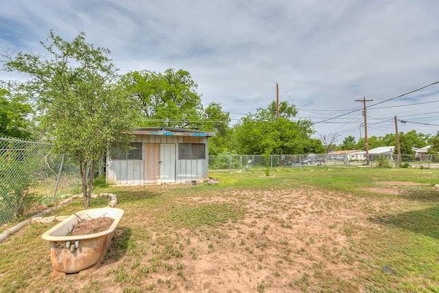 view of yard featuring an outdoor structure, a fenced backyard, and a storage shed