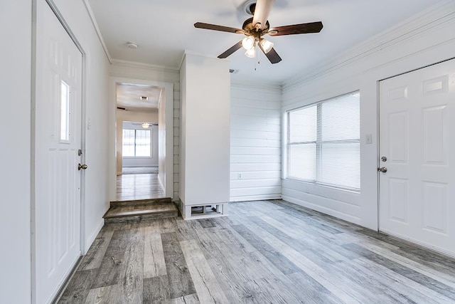 foyer with crown molding, ceiling fan, baseboards, and wood finished floors