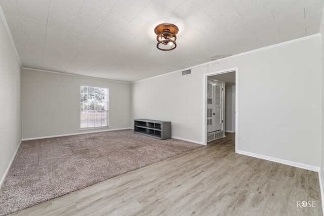 unfurnished living room featuring crown molding and light wood-type flooring