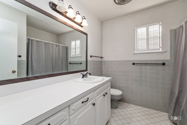 bathroom with vanity, plenty of natural light, tile walls, and tile patterned floors