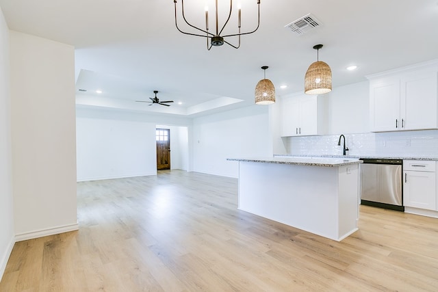 kitchen featuring pendant lighting, white cabinets, a center island, stainless steel dishwasher, and light stone countertops