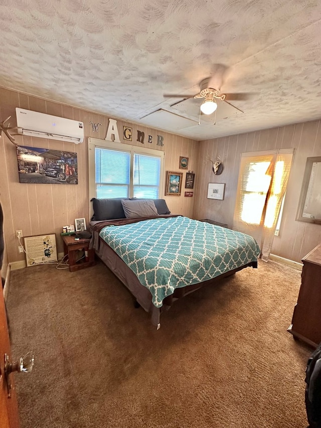 1501 Bishop St, Robert Lee, TX 76945 - bedroom with a wall mounted air conditioner, a textured ceiling, carpet flooring, wood walls, and ceiling fan