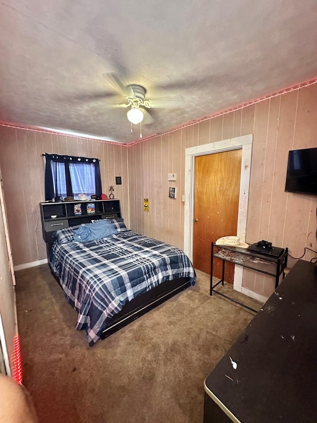 1501 Bishop St, Robert Lee, TX 76945 - carpeted bedroom with wood walls and ceiling fan