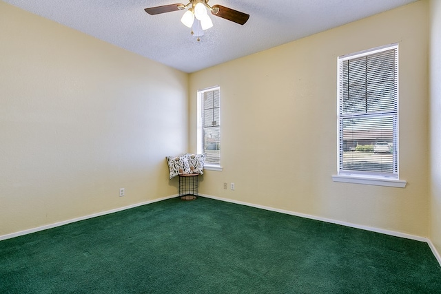 carpeted empty room featuring ceiling fan, baseboards, and a textured ceiling