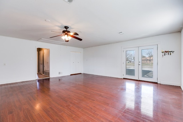 unfurnished room featuring french doors, baseboards, attic access, and wood finished floors