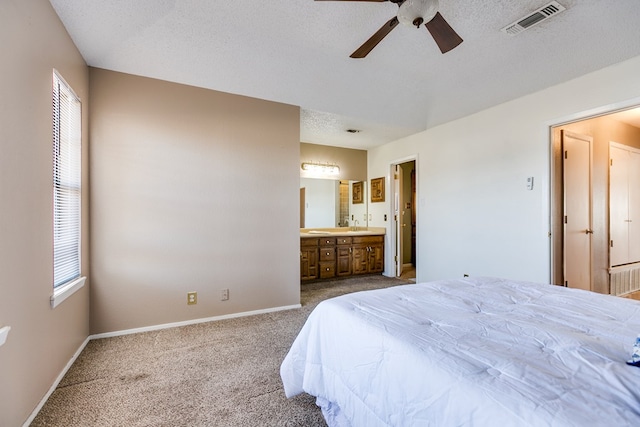 bedroom with visible vents, multiple windows, a textured ceiling, and dark colored carpet