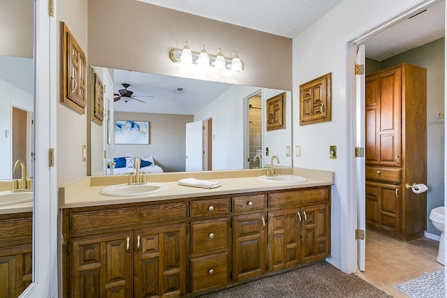 ensuite bathroom featuring a sink, double vanity, ensuite bathroom, and tile patterned flooring