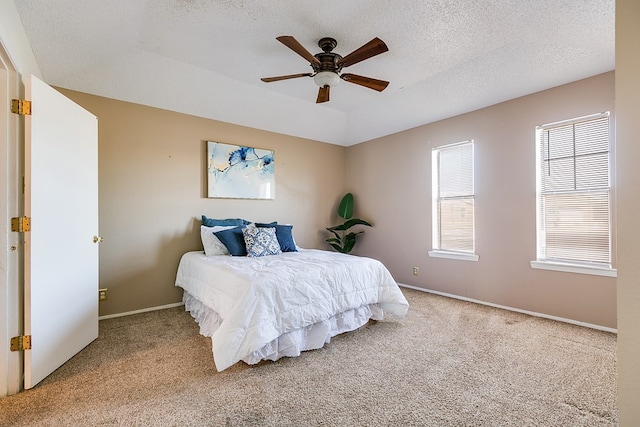 bedroom with baseboards, a textured ceiling, ceiling fan, and carpet flooring