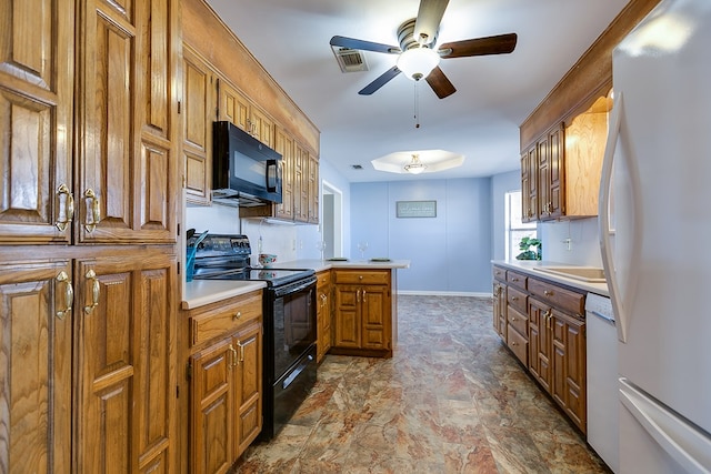 kitchen with visible vents, black appliances, brown cabinetry, light countertops, and baseboards