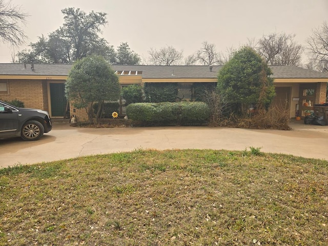 view of front facade with driveway and brick siding