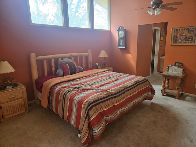 carpeted bedroom featuring ceiling fan and ensuite bath