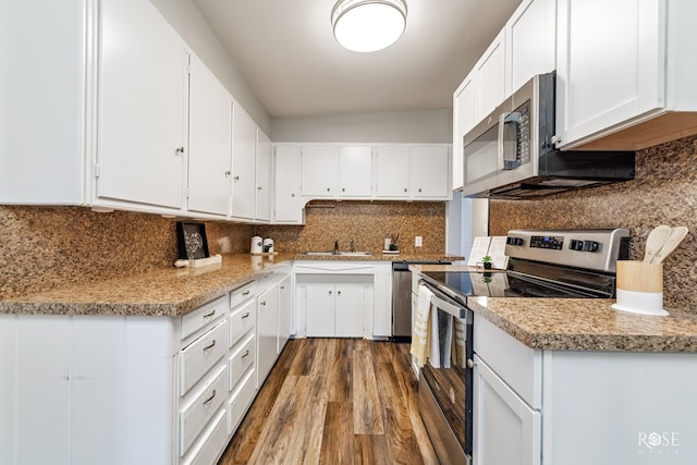 kitchen with tasteful backsplash, stainless steel appliances, and white cabinets