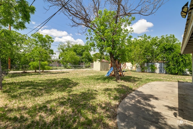 view of yard with an outdoor structure, a fenced backyard, a patio area, and a storage shed